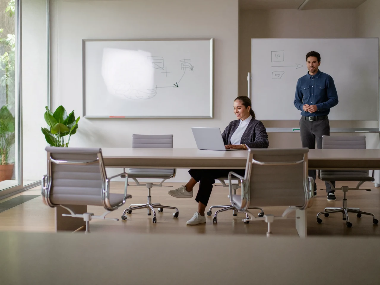 Salle de formation lumineuse où des adultes travaillent sur ordinateur autour d'un formateur
